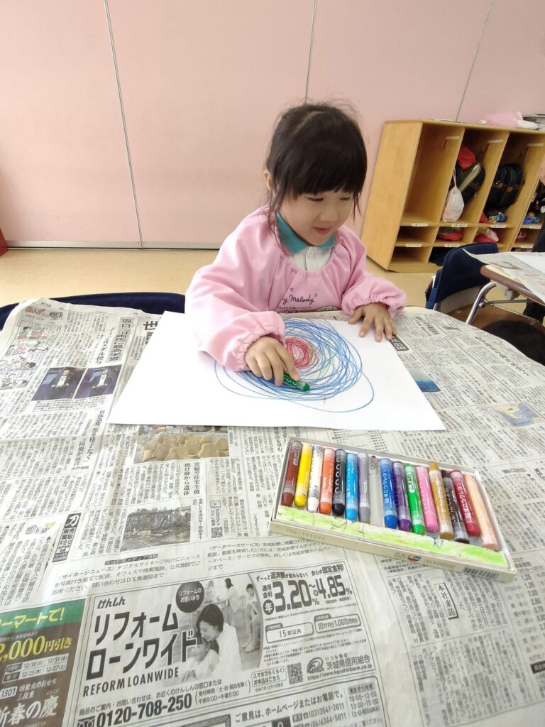 クレヨンを大きく動かして、色を重ねていくうめ組さん(3歳児クラス)