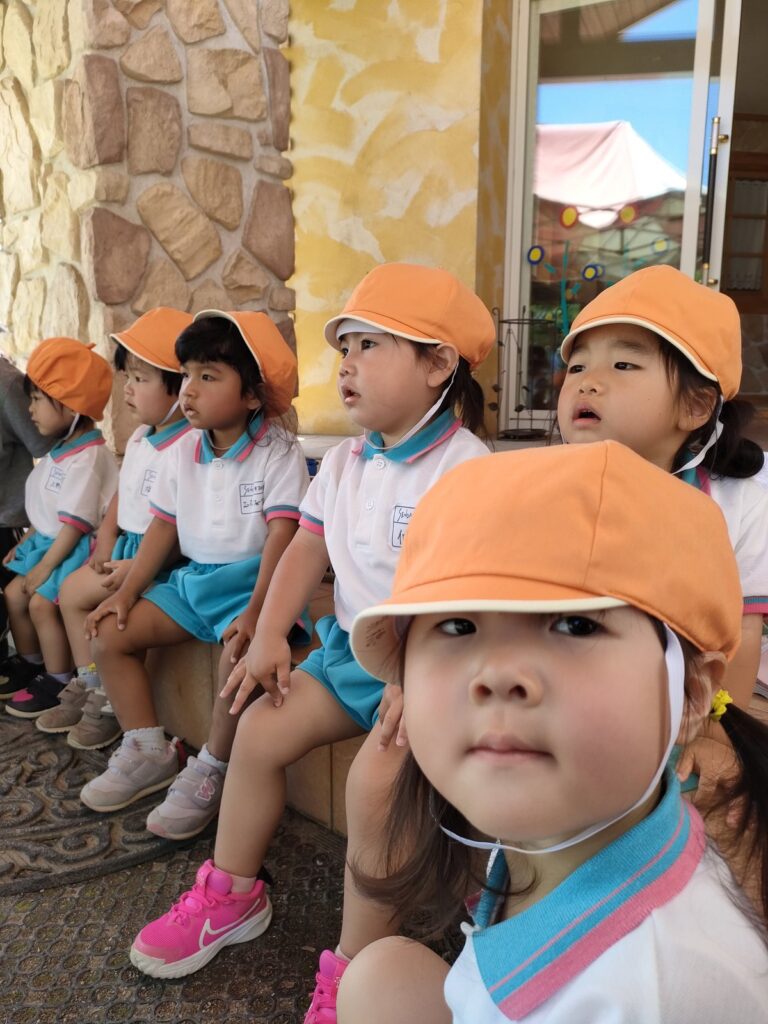 お兄さん・お姉さんの競技をじっと見つめるいちご組(2歳児クラス)さん