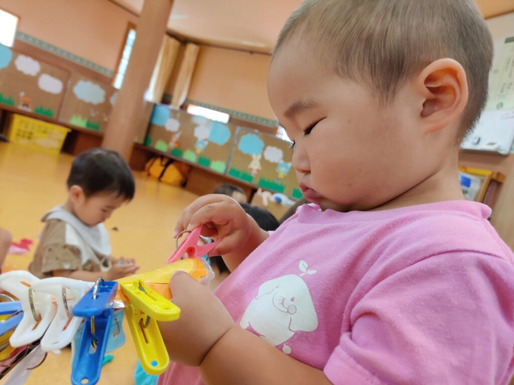 洗濯バサミをひとつ、またひとつ。「できた!」が積み重なるすみれ組さん(1歳児クラス)の手元