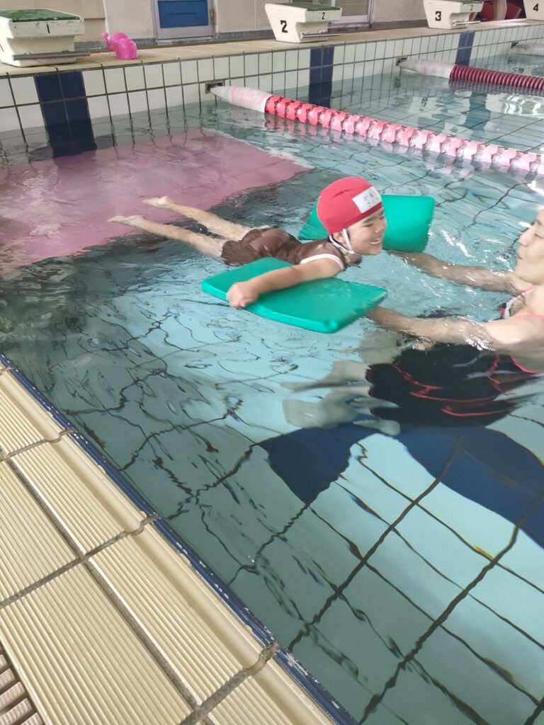 ビート板にお腹をあずけて、水の上でプカプカ浮かぶもも組さん(4歳児クラス)