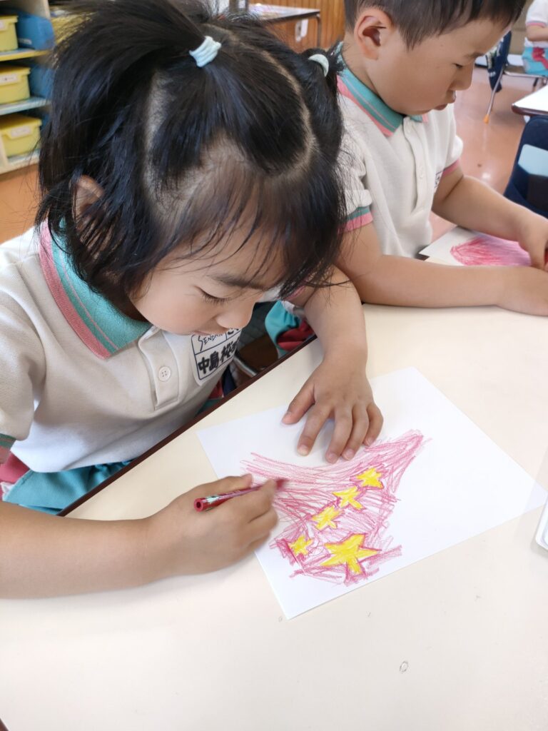 描きたい国を選び、色を丁寧にのせていくさくら組(5歳児クラス)の万国旗づくり