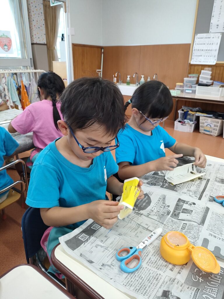 切る細さのちがう提灯を見せ合うさくら組さん(5歳児クラス)。「僕は細かくいっぱい」「私は十個くらい」