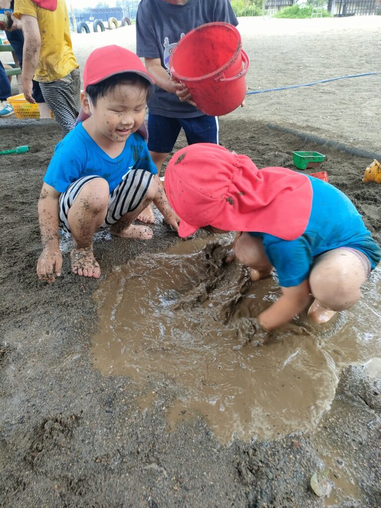 掘った川に水を流して、みんなで泥んこになるうめ組さん(3歳児クラス)