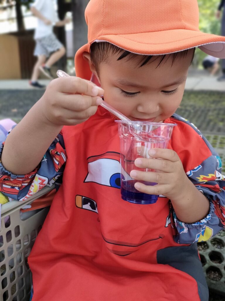 色水がゆっくり紫に変わっていく瞬間を見つめるいちご組さん（2歳児クラス）