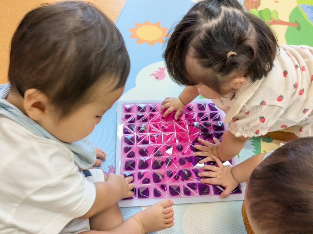 指先で触れた液体がジュワッと形を変えていくのを、じっと見つめるひよこ組さん（0歳児クラス）