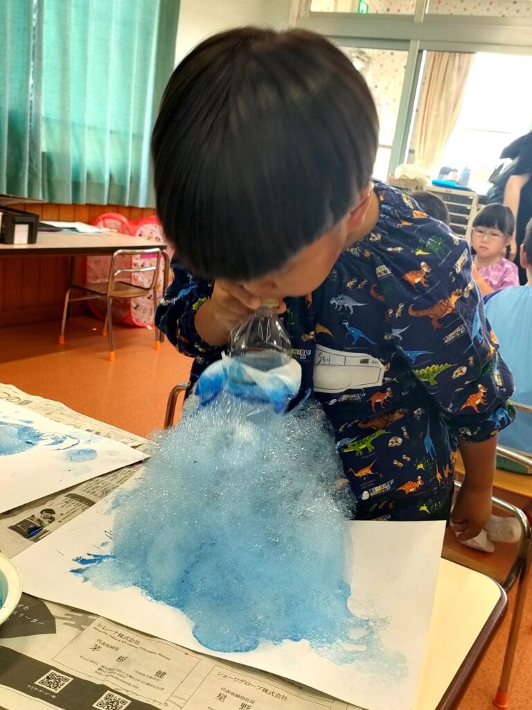 ストローで吹き込んだ細かい泡を高く高く積み重ねていくさくら組さん（5歳児クラス）