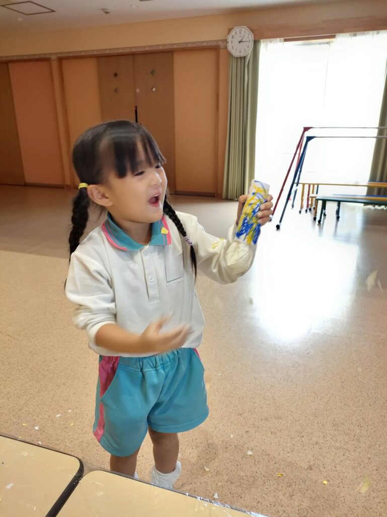風船を引くと、折り紙がポーンと飛び出した瞬間（うめ組・3歳児クラス）