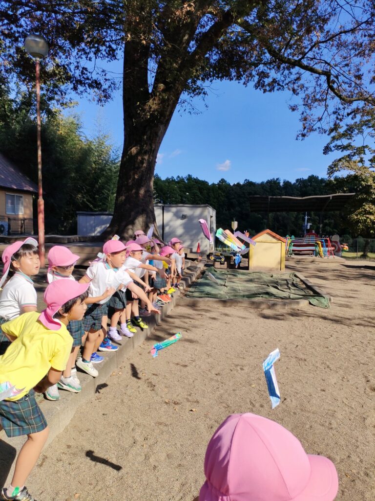 できあがった紙飛行機を、園庭で何度も飛ばすさくら組さん（5歳児クラス）